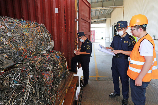 Më 13 gusht 2019, punonjësit e Doganës së Portit Ningbo të Kinës Lindore mbikëqyrën tërheqjen e mbetjeve të ngurta në konteiner/ VCG