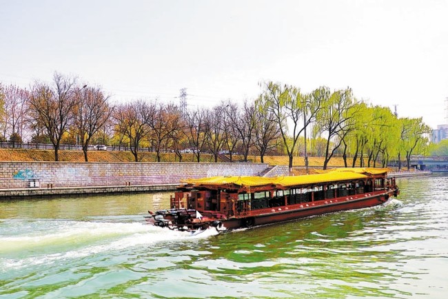 Loď pluje po řece Changhe (Čchang-che) v Pekingu, která protéká městskými památkami, jako je Park fialového bambusu. [Fotografie: Xu Lin / Deník China Daily]