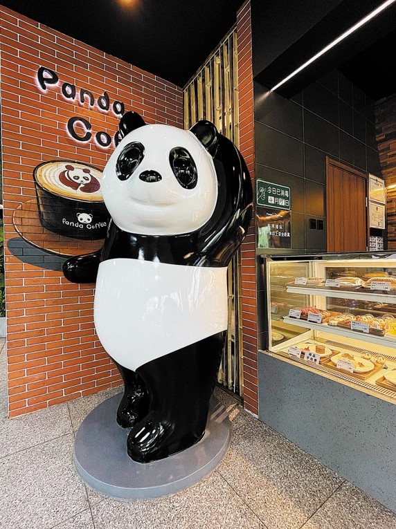 Panda pozdraví návštěvníky u kavárny. [Fotografie: Xu Lin / deník China Daily]