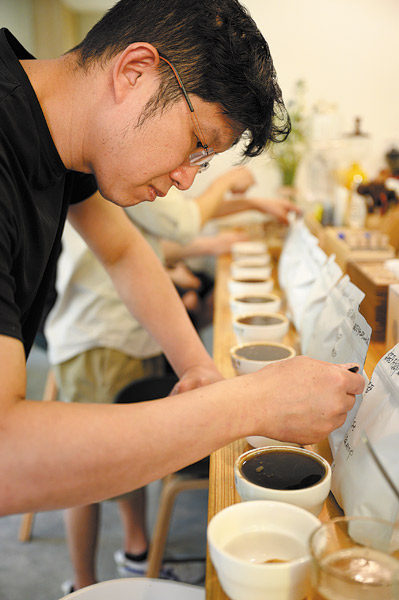 Tsai Hsi-Ching dělá kávu ve svém obchodě. [Fotografie: Chen Chuhong (Čchen Čchu-chung) / China News Service]