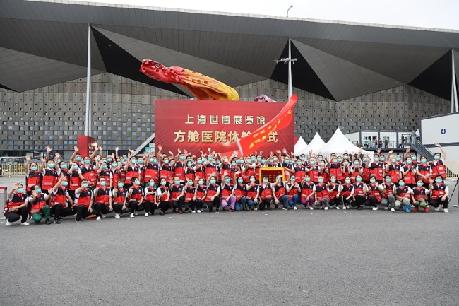 Des membres de l'équipe médicale d’aide à Shanghai contre la dernière flambée de COVID-19 de la province du Fujian (sud-est de la Chine) assistent à la cérémonie de clôture de l'hôpital de fortune construit sur la base de la conversion du Centre national des expositions et des congrès de Shanghai, le 25 mai 2022.(Photo/VCG)