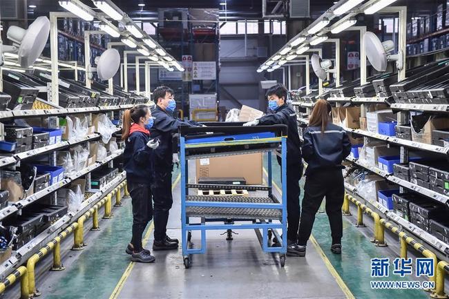 Mit Schutzmasken vermummten Arbeiter in der Werkstatt eines Automobilunternehmens in Beijing.