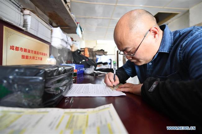 Ai Peng füllt Einlieferungsscheine für Kurierdienst aus<br>Foto von Xinhua