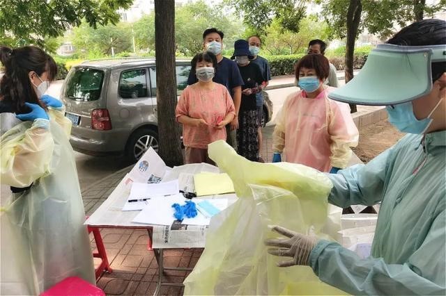 Freiwillige und Mitarbeiter des Wohnviertels arbeiten zusammen, um die Testarbeit zu organisieren und die positiv Getesteten zu behandeln.