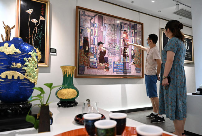 Οι λάτρεις της λάκας παρατηρούν πίνακες από λάκα στο Κτίριο Τεχνών και Χειροτεχνίας της επαρχίας Φουτζιέν στις 28 Ιουλίου. [Φωτογραφία/Xinhua]