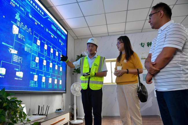 Εργαζόμενος της Golden Cooperate Information & Automation Technology Co δείχνει τα δεδομένα παρακολούθησης που συλλέχθηκαν από το νέο σύστημα ηλιακής ενέργειας στο χωριό Τζουανγκσάνγκ του Γιουντσένγκ της επαρχίας Σανσί. [Φωτογραφία / chinadaily]