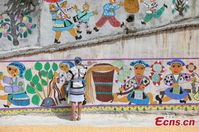 Ζωγράφος της εθνότητας των Μιάο επιδιορθώνει τοιχογραφίες (壁画 Bìhuà) που έχουν γίνει σύμφωνα με το στυλ των Μιάο στο χωριό Πινγκπό της κομητείας Λονγκλί της Αυτόνομης Νομαρχίας Τσιεννάν Μπουγί και Μιάο, στην επαρχία Γκουιτζόου της νοτιοδυτικής Κίνας, στις 15 Σεπτεμβρίου 2021