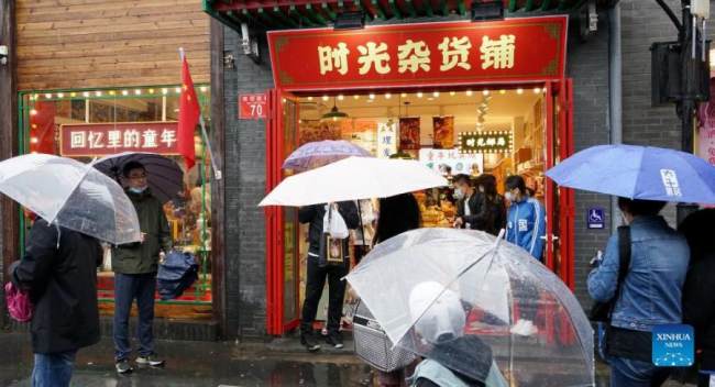Κόσμος μπροστά από μαγαζιά στην Οδό Νανλουογκουσιάνγκ στο Πεκίνο κατά την διάρκεια των 7ήμερων διακοπών για την Εθνική Ημέρα της Κίνας, στις 6 Οκτωβρίου 2021