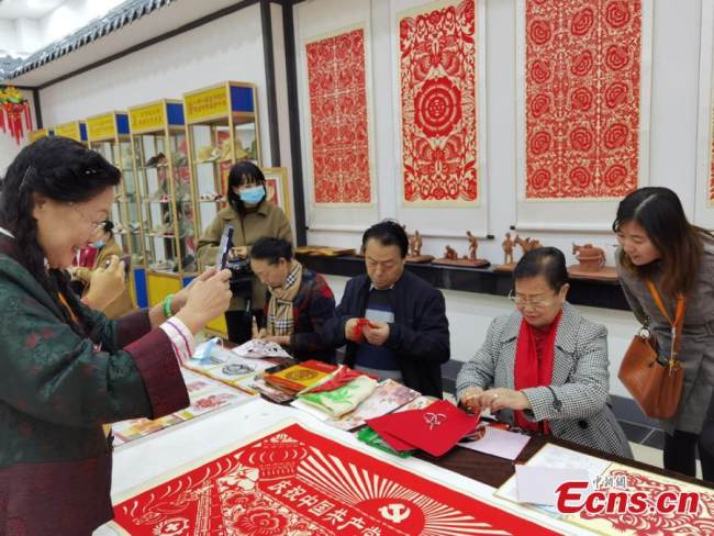 Τεχνίτριες παρουσιάζουν σχέδια χαρτοκοπτικής στην τοπική έκθεση που έγινε στο Λαντζόου, επαρχία Γκανσού, στις 17 Οκτωβρίου 2021.