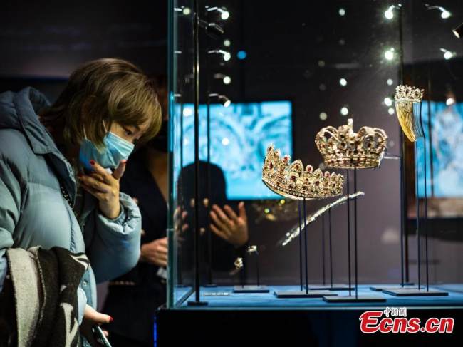 Μια γυναίκα παρατηρεί ένα αντίγραφο ενός σετ από ρουμπίνια και διαμάντια που έδωσε ο Ναπολέων Βοναπάρτης στη δεύτερη σύζυγό του, Μαρί Λουίζ, στην έκθεση κοσμημάτων «Όνειρο του Στέμματος» που πραγματοποιήθηκε στο The Red, στην περιοχή Σανλιτούν στο Πεκίνο, στις 8 Νοεμβρίου 2021. (Φωτογραφία: China News Service)