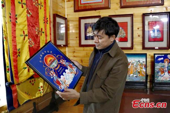 Ο κληρονόμος των θάνγκκα Χουαλόνγκ, Γκενγκντένγκ Τσαϊράνγκ, δείχνει ένα έργο τέχνης στο εργαστήριό του στην κομητεία Χουαλόνγκ, στην επαρχία Τσινγκχάι της βορειοδυτικής Κίνας, 22 Νοεμβρίου 2021. (Φωτογραφία: China News Service)
