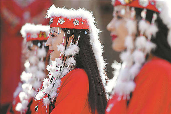 Χορευτές ντυμένοι με παραδοσιακή ενδυμασία είναι ένα συνηθισμένο θέαμα στην "πόλη του τραγουδιού και του χορού". [Φωτογραφία/China Daily]