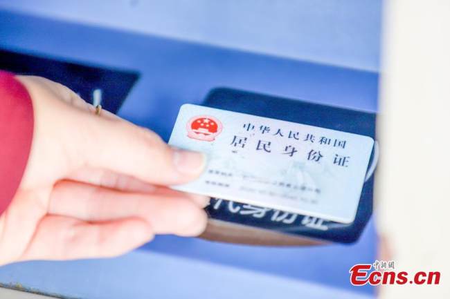 Επιβάτες κάνουν check-in στο σιδηροδρομικό σταθμό Ναντσάνγκ στην επαρχία Τζιανγκσί της ανατολικής Κίνας, 3 Ιανουαρίου 2021. (Φωτογραφία/China News Service)