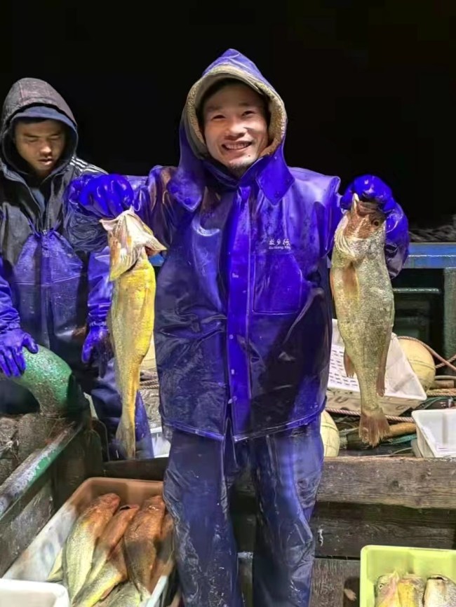 Ο Γιανγκ Τιενσένγκ, ένας ψαράς από την κομητεία Σιανγκσάν, στην επαρχία Τζετζιάνγκ, δείχνει τι ψάρεψε στις 15 Ιανουαρίου 2022. [Η φωτογραφία παρέχεται στην China Daily]
