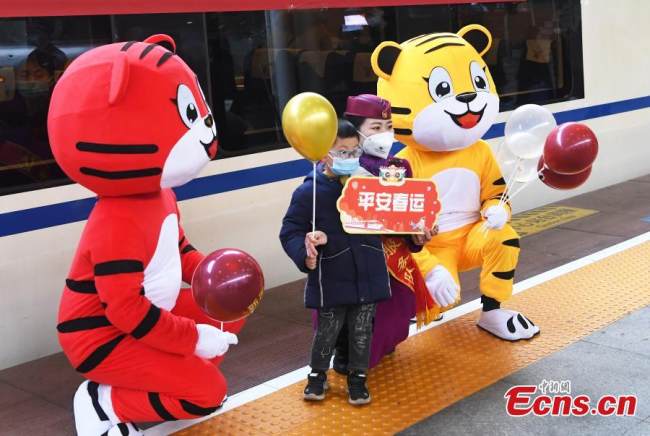 Ένα αγόρι ποζάρει για φωτογραφίες μαζί με τις «τίγρεις» (老虎: lǎohǔ) συνοδούς στο Τσονγκτσίνγκ, νοτιοδυτική Κίνα, στις 17 Ιανουαρίου 2022.