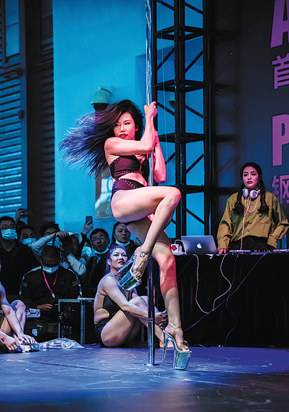 Η Σου Γιανσιά, συνιδιοκτήτρια του στούντιο, παρακολουθεί έναν διαγωνισμό pole-dancing το 2021. [Η φωτογραφία παρέχεται στην China Daily]