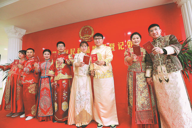 Νιόπαντρα ζευγάρια βγάζουν μια ομαδική φωτογραφία με τα πιστοποιητικά γάμου τους σε ένα γραφείο εγγραφής γάμων στο Λιενγιουνγκάνγκ, στην επαρχία Τζιανγκσού, την Τρίτη. Πολλοί Κινέζοι θεωρούν την 22η Φεβρουαρίου 2022, μια ευοίωνη και σπάνια ημερομηνία γάμου καθώς η προφορά του "δύο" στα κινέζικα ακούγεται σαν "αγάπη". Η Τρίτη ήταν διπλά ευοίωνη καθώς ήταν η 22η ημέρα του πρώτου κινεζικού σεληνιακού μήνα. [Φωτογραφία/ China Daily]