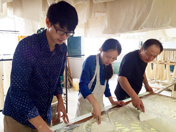 Ο Νι Σεντζιάν (αριστερά), η σύζυγός του και ο πεθερός του φτιάχνουν όλοι μαζί ένα ύφασμα στο μουσείο τους στο Ναντόνγκ της επαρχίας Τζιανγκσού. [Η φωτογραφία παρέχεται στην China Daily]