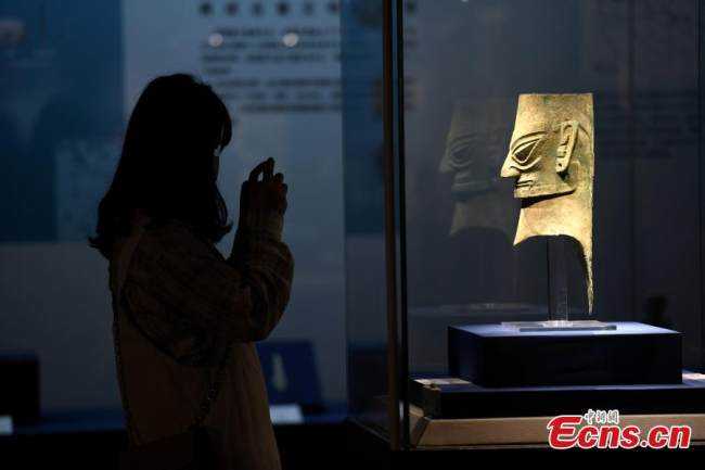 Ένας επισκέπτης βγάζει φωτογραφίες του χάλκινου ανθρώπινου κεφαλιού που φορά μια χρυσή μάσκα στο Μουσείο Φουτζιέν, της πόλης Φουτζόου, στην επαρχία Φουτζιέν στην νοτιοανατολική Κίνα, στις 12 Μαΐου 2022. (Φωτογραφία: China News Service) 