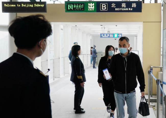 Ένας επιβάτης δείχνει τον κωδικό QR υγείας του πριν μπει σε σταθμό του μετρό στο Πεκίνο, πρωτεύουσα της Κίνας, 17 Μαΐου 2022. 