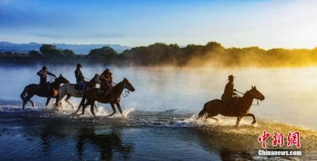Άλογα καλπάζουν κατά μήκος του ποταμού Τέκες στην κομητεία Τζαοσού, στον αυτόνομο νομό Καζάκ του Ιλί, στην αυτόνομη περιοχή Σιντζιάνγκ Ουιγκούρ της βορειοδυτικής Κίνας, στις 20 Ιουνίου 2022. (Φωτογραφία: China News Service)