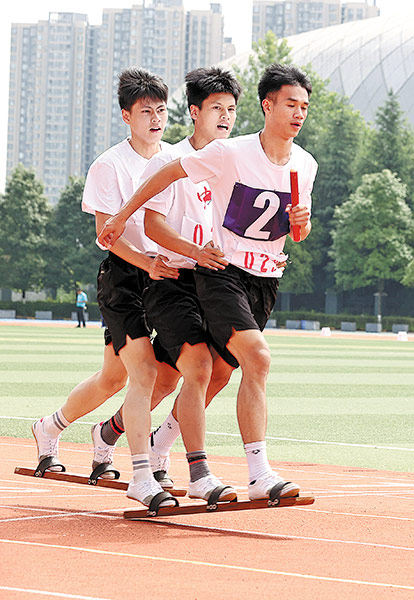 Οι αγώνες παπουτσιών είναι ένα παιχνίδι στο οποίο τρεις αθλητές φορούν ξύλινες παντόφλες από δύο ξύλινες σανίδες για να αγωνιστούν. [Η φωτογραφία παρέχεται στην China Daily]
