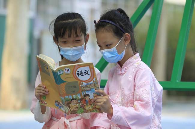 Δύο μαθητές φορώντας χάνφου στο Δημοτικό Σχολείο Σιγουάνγκ του Τσιαοσί στην πρωτεύουσα της επαρχίας Χεμπέι, Σιτζιατζουάνγκ, διαβάζουν βιβλία. [Η φωτογραφία παρέχεται στο chinadaily.com.cn] 