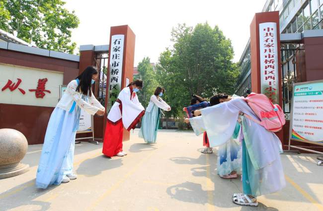 Οι δάσκαλοι καλωσορίζουν τους μαθητές στη σχολική πύλη του Δημοτικού Σχολείου Σιγουάνγκ στην περιοχή Τσιαοσί του Σιτζιατζουάνγκ, στην επαρχία Χεμπέι. [Η φωτογραφία παρέχεται στο chinadaily.com.cn] 