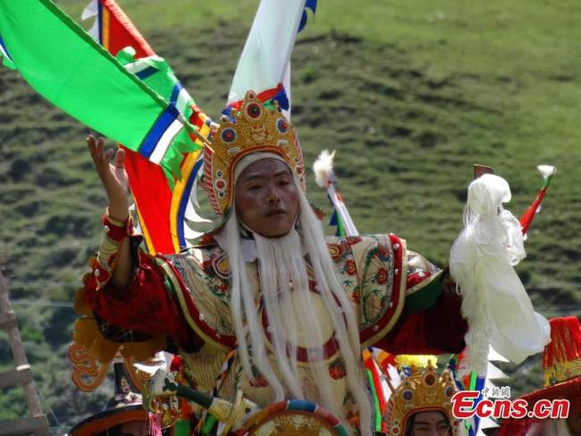 Ένας ερμηνευτής από τον Θίασο της Θιβετιανής Όπερας παίζει ένα θιβετιανό κομμάτι όπερας βασισμένο στο Έπος του Βασιλιά Γκεσάρ στην κομητεία Μπάνμα, στην επαρχία Τσινγκχάι. (Η φωτογραφία παρέχεται στην υπηρεσία China News Service) 