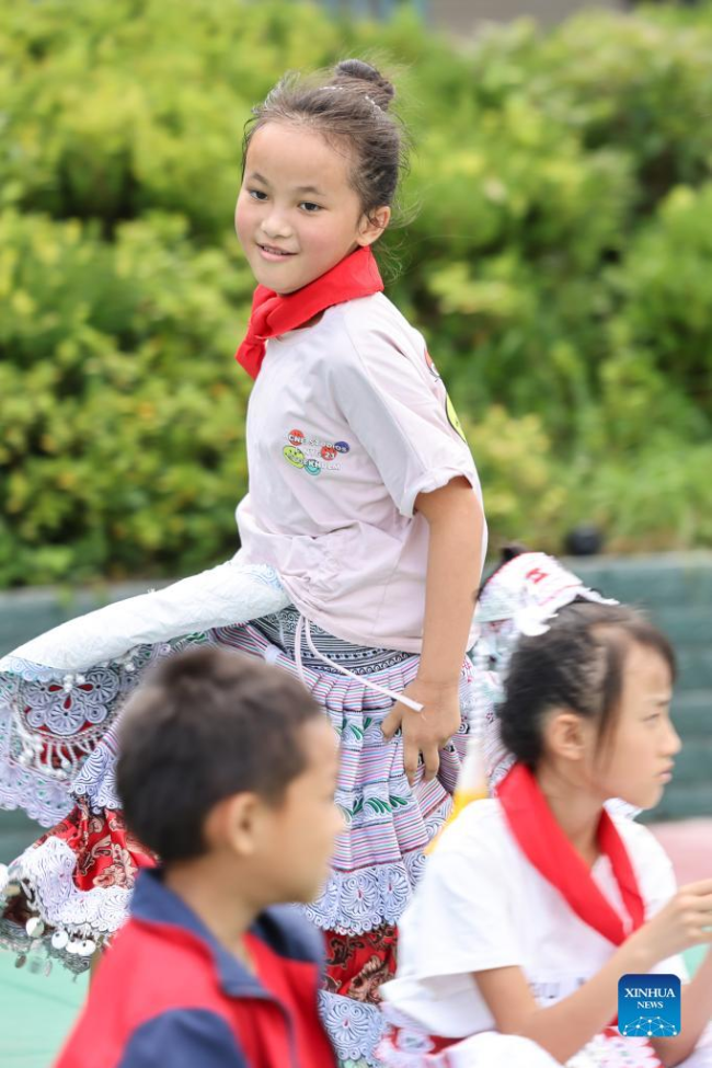 Η Γιανγκ Γιαμένγκ, (πίσω) συμμετέχει σε ένα παιχνίδι με τους συμμαθητές της σε ένα δημοτικό σχολείο στο χωριό Χουαγού της πόλης Σινρέν Μιάο, στην πόλη Τσιανσί της επαρχίας Γκουιτζόου της νοτιοδυτικής Κίνας, 1 Ιουνίου 2022. 