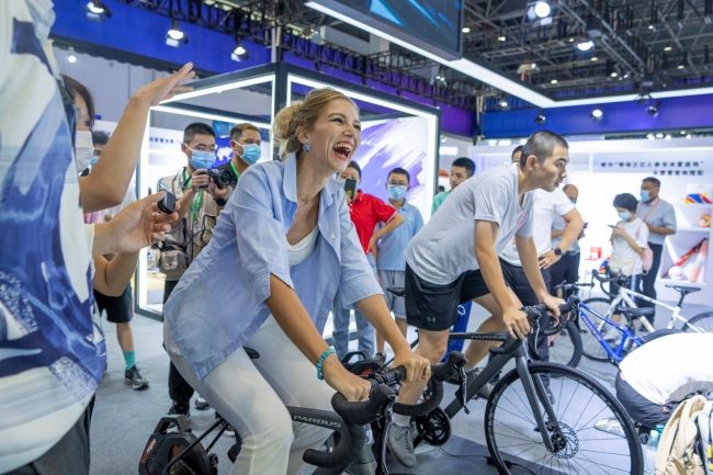 Επισκέπτες δοκιμάζουν ποδηλασία στη 2η έκθεση China International Consumer Products Exp, στις 28 Ιουλίου 2022. (People's Daily Online/Yuan Chen)