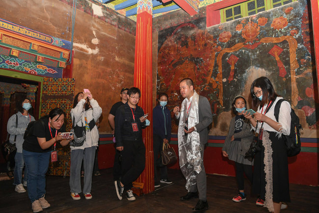 Un responsabil al Centrului Artistic Jebum-gang prezintă vizitatorilor arhitectura și frescele din clădirea veche Jebun-gang Lha-khang.